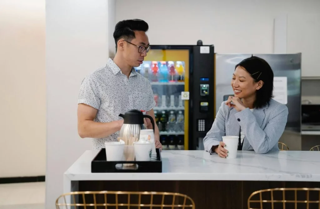 photo de deux collègues discutant devant un distributeur automatique de snack