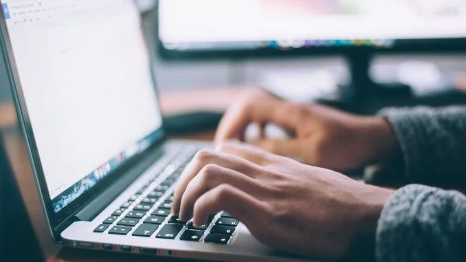 Image d'une personne tapant sur son clavier pour rédiger un contrat de maintenance.