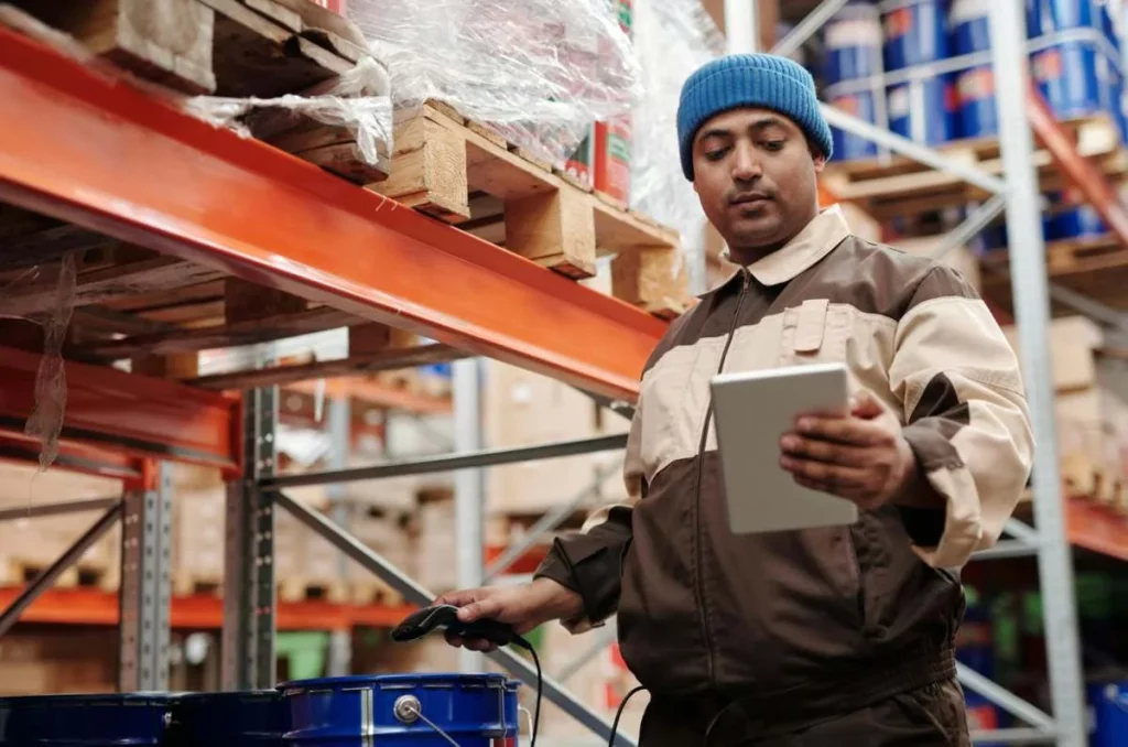 homme dans un entrepôt avec un outil d'ordonnancement logistique