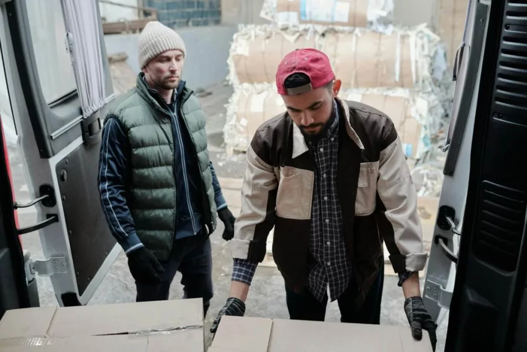 photo de deux ouvriers en plein déchargement d'un camion selon le protocole de chargement et déchargement 