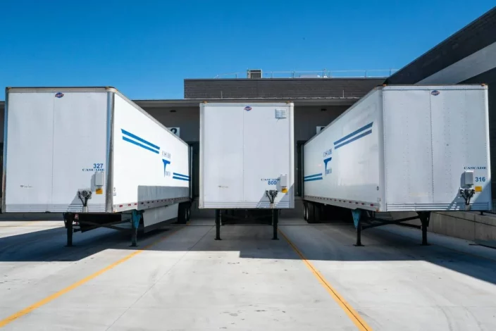 photo de trois camions prêt pour chargement et déchargement selon le protocole du code du travail